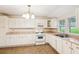 Cozy kitchen features white appliances, plenty of cabinets, and lots of natural light at 106 N Pine St, Summerville, SC 29483