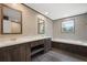 Elegant bathroom with dual sinks, a soaking tub, wood cabinets, and a large mirror at 108 Swanson Dr, Summerville, SC 29483