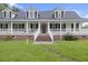 Up close exterior of the home's porch featuring white columns, a decorated front door, and a brick foundation at 117 Ponderosa Rd, Summerville, SC 29483