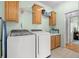 The laundry room has a set of front load washer and dryer and wood cabinets at 117 Ponderosa Rd, Summerville, SC 29483