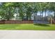 Large, grassy backyard featuring a trampoline, swing set, and tall wooden fence for privacy at 1250 White Tail Path, Charleston, SC 29414