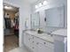 Bright bathroom with a double sink vanity with marble countertop and mirrors, next to a walk-in closet at 1250 White Tail Path, Charleston, SC 29414