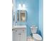 Powder room with blue walls, white vanity and silver framed mirror at 1250 White Tail Path, Charleston, SC 29414
