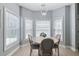 A well-lit dining area with a round table, four chairs, and multiple windows that provide plenty of natural light at 1250 White Tail Path, Charleston, SC 29414