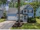 Charming blue two-story home with a well-manicured lawn, white trim, and attached two-car garage at 1250 White Tail Path, Charleston, SC 29414