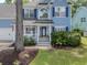 Inviting blue home with a white porch, tidy landscaping, and a charming, welcoming facade at 1250 White Tail Path, Charleston, SC 29414