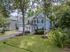 Beautiful two-story blue home with a white porch and meticulously landscaped lawn at 1250 White Tail Path, Charleston, SC 29414