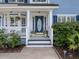 Close-up of the front porch featuring an oval front door, stylish planters, and classic white columns at 1250 White Tail Path, Charleston, SC 29414