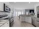 Modern kitchen with stainless steel appliances and tile backsplash leading into the dining area at 1250 White Tail Path, Charleston, SC 29414