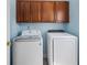 This laundry room features a modern washer and dryer set with wood cabinets above offering convenient storage space at 1250 White Tail Path, Charleston, SC 29414