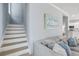 Cozy living room features stairs, modern artwork and comfortable gray sofa at 1250 White Tail Path, Charleston, SC 29414