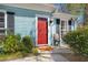Close-up of the front door featuring a bright red door, black shutters, and an outdoor chair at 130 Shropshire St, Goose Creek, SC 29445