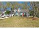 Charming single-Gathering home featuring a well-manicured front lawn, a two-car garage, and a bright red front door at 130 Shropshire St, Goose Creek, SC 29445