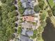 Aerial view of a residential neighborhood with lush trees, houses with dark roofs and solar panels, and a pond at 134 Etiwan Park St, Charleston, SC 29492