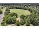 Aerial view showcasing the community park, featuring a large grassy field, playground, and surrounding lush greenery at 134 Etiwan Park St, Charleston, SC 29492