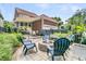 A backyard featuring a stone fire pit surrounded by blue Adirondack chairs, lush greenery, and manicured landscaping at 134 Etiwan Park St, Charleston, SC 29492