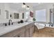 Bathroom featuring double sinks, quartz countertops, wood-look tile, a tub and glass shower at 134 Etiwan Park St, Charleston, SC 29492