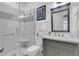 Bright bathroom featuring a glass enclosed shower with bench and gray vanity with black framed mirror at 134 Etiwan Park St, Charleston, SC 29492