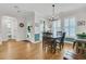 Sunlit dining room features hardwood floors, plantation shutters, a stylish light fixture, and neutral wall colors at 134 Etiwan Park St, Charleston, SC 29492