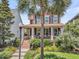 Beautiful two-story home with a welcoming front porch, lush landscaping, and mature palm trees at 134 Etiwan Park St, Charleston, SC 29492