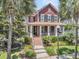 Charming two-story home featuring a cozy front porch, well-manicured landscaping, and beautiful palm trees at 134 Etiwan Park St, Charleston, SC 29492