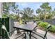 Outdoor patio with a table and four chairs overlooking a lush garden with plants, flowers, and mature trees at 134 Etiwan Park St, Charleston, SC 29492