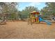 Community playground with a wooden play structure, swings, picnic table, and mature trees at 134 Etiwan Park St, Charleston, SC 29492