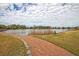 Scenic pond with a curved brick walking path and grassy areas, offering a tranquil outdoor setting for residents at 134 Etiwan Park St, Charleston, SC 29492