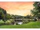 Scenic view of a tranquil pond reflecting the sky, surrounded by lush greenery and trees at 134 Etiwan Park St, Charleston, SC 29492