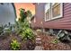 The yard has rocks and plants including palms and is adjacent to a house with two visible windows at 134 Etiwan Park St, Charleston, SC 29492
