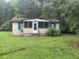 Modest single-story home with a screened-in porch and a white front door surrounded by green foliage at 137 Droze Rd, Summerville, SC 29483