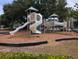 Community playground with slides, climbing structure, and a swing set in a wooded area at 164 Historic Dr, Mount Pleasant, SC 29464