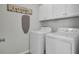 Efficient laundry room with modern washer and dryer, overhead cabinets, and ironing board at 165 Clydesdale Cir, Summerville, SC 29486