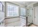 Bathroom featuring a soaking tub and glass shower with pebble-stone flooring at 1868 Palmetto Isle Dr, Mount Pleasant, SC 29466