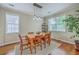 Bright dining room with natural wood table, six chairs, modern light fixture, and hardwood floors at 1868 Palmetto Isle Dr, Mount Pleasant, SC 29466