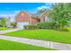Beautiful brick house with lush green lawn, mature landscaping, and a sunny blue sky at 1868 Palmetto Isle Dr, Mount Pleasant, SC 29466