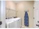 Laundry room with front loading washer and dryer, wire shelving, and ironing board at 1868 Palmetto Isle Dr, Mount Pleasant, SC 29466