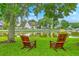 Inviting view features Adirondack chairs facing a tranquil pond surrounded by mature trees and greenery at 1868 Palmetto Isle Dr, Mount Pleasant, SC 29466