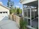 View of a garage, screened-in porch, backyard area, and patio furniture, all enclosed by a wooden fence at 198 Winding Branch Dr, Summerville, SC 29486