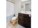 Bright bathroom featuring dark wood vanity, neutral tile floors, and shower with patterned curtain at 199 Meadow Wood Rd, Summerville, SC 29486