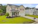 Charming two-story home with a well-manicured lawn and front porch seating area at 199 Meadow Wood Rd, Summerville, SC 29486