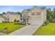 Well-kept two-story home with a spacious driveway, green lawn, and covered front porch at 199 Meadow Wood Rd, Summerville, SC 29486