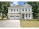 Charming two-story home boasts a welcoming front porch, manicured lawn, and an attached two-car garage at 2004 Sea Water Dr, Charleston, SC 29412