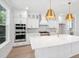 Modern kitchen with large center island, pendant lighting, and stainless steel appliances at 2004 Sea Water Dr, Charleston, SC 29412