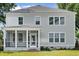 Rear exterior of home featuring an enclosed porch, backyard lawn and tidy landscaping at 2004 Sea Water Dr, Charleston, SC 29412