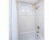 Clean bathroom with white subway tile, a white tub, and a window with shutters at 202 Fishburne St, Charleston, SC 29403