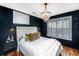 Chic bedroom with a crystal chandelier, dark walls and modern decor at 202 Fishburne St, Charleston, SC 29403
