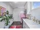 Stylish kitchen featuring white cabinets, gold hardware, and a vintage-inspired pink refrigerator at 202 Fishburne St, Charleston, SC 29403