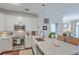 Bright kitchen features white cabinets, stainless steel appliances, and an island with marble countertop and wicker barstools at 21 George St # 203, Charleston, SC 29401
