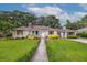 Charming single-story home featuring a well-manicured lawn, stone walkway, and inviting front entrance at 22 Charlestowne Rd, Charleston, SC 29407